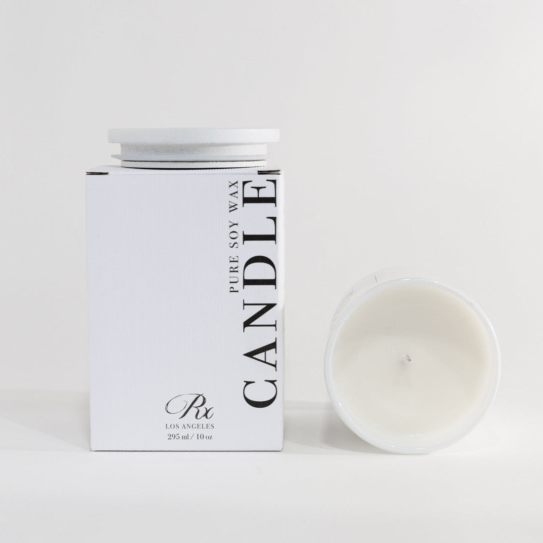 Candle packaging with a white candle on a light gray background