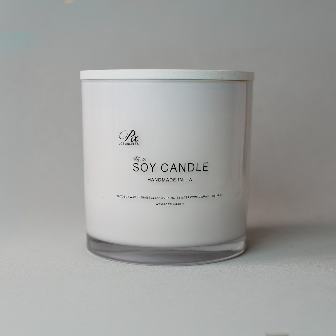 White soy candle with a label on a light gray background