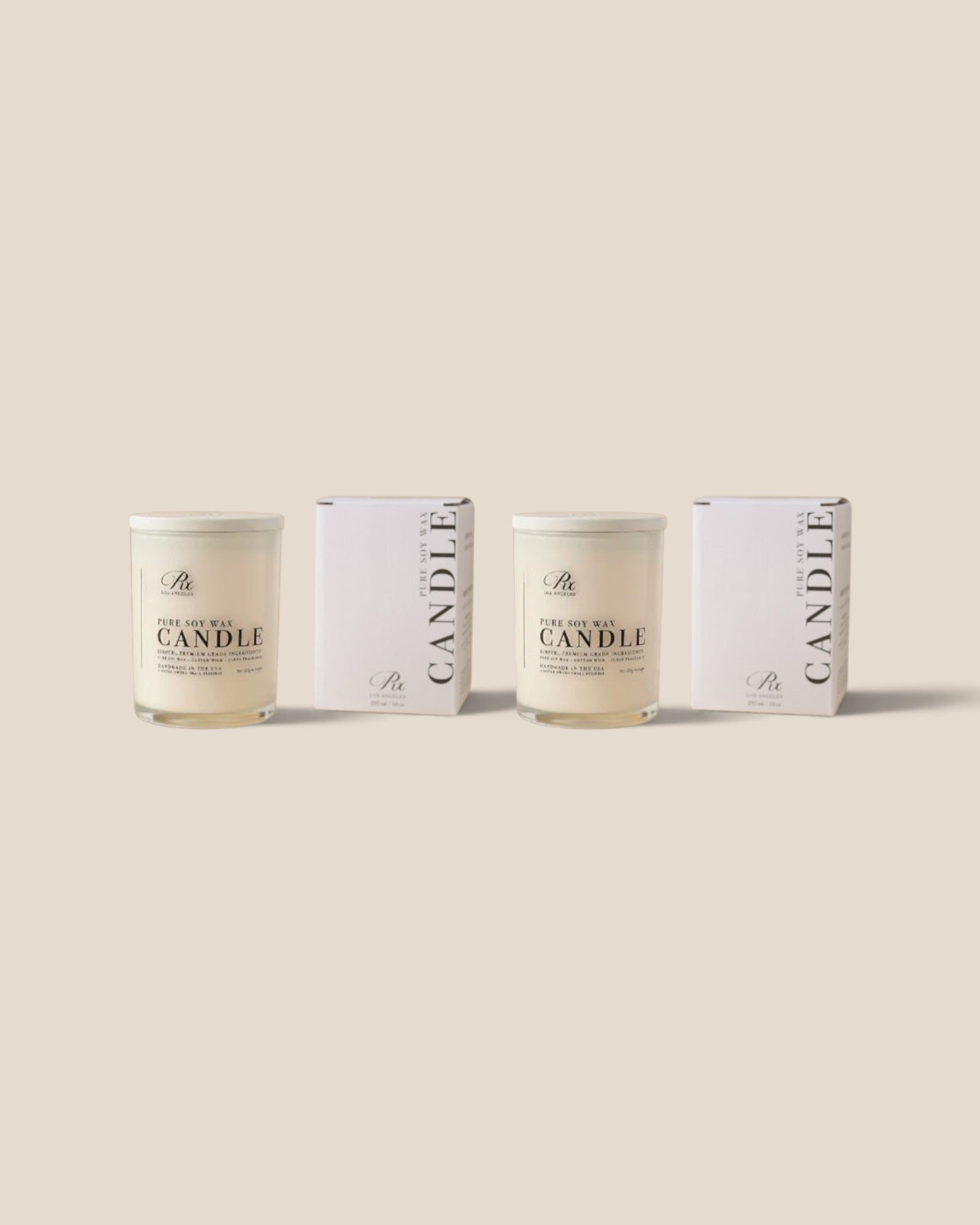 Two glass jar candles with cream-colored wax and white lids, displayed alongside their matching white packaging boxes on a solid beige background.