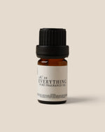 A small amber glass bottle of fragrance oil with a black ribbed cap and a white label reading 'K.08 EVERYTHING PURE FRAGRANCE OIL', centered on a warm beige background.