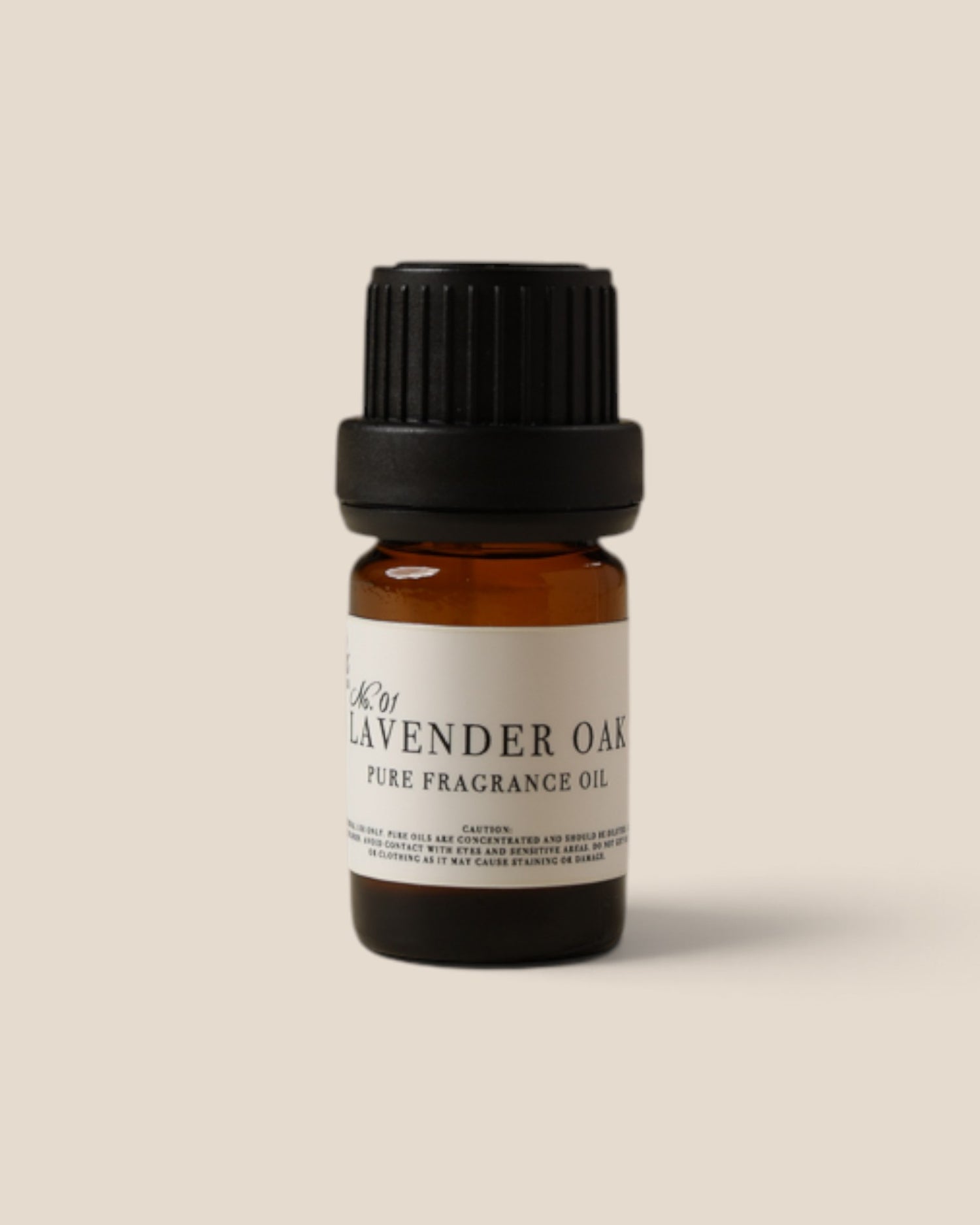 A small amber glass bottle of Lavender Oak Pure Fragrance Oil with a black ribbed cap and a cream label, centered on a solid beige background.