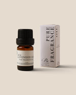 A bottle of Lavender Oil fragrance oil next to its white packaging box, both featuring black text and a black cap, set against a solid beige background.