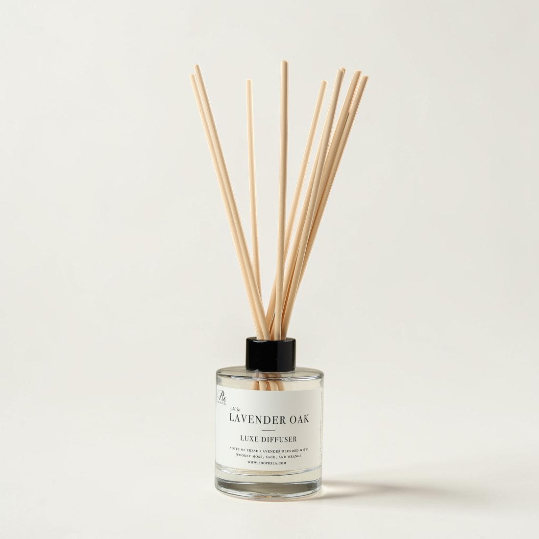 A reed diffuser bottle with natural wood reeds, a black cap, and a white label reading 'A La LAVENDER OAK LUXE DIFFUSER' on a clean off-white background.