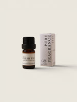 A small amber glass bottle with a black cap and a cream label reading 'FRESH FIG FRAGRANCE OIL' stands next to its matching cream-colored box with vertical text, on a plain warm off-white background.