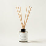 A South Hampton reed diffuser bottle with a clear glass container, white label, black cap, and natural wood reeds, photographed on a clean off-white background.