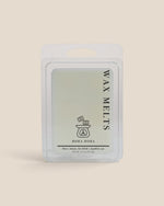 A wax melt package in a clear plastic clamshell with a white hanging tab, labeled 'WAX MELTS' and 'BORA BORA' on a warm beige background.