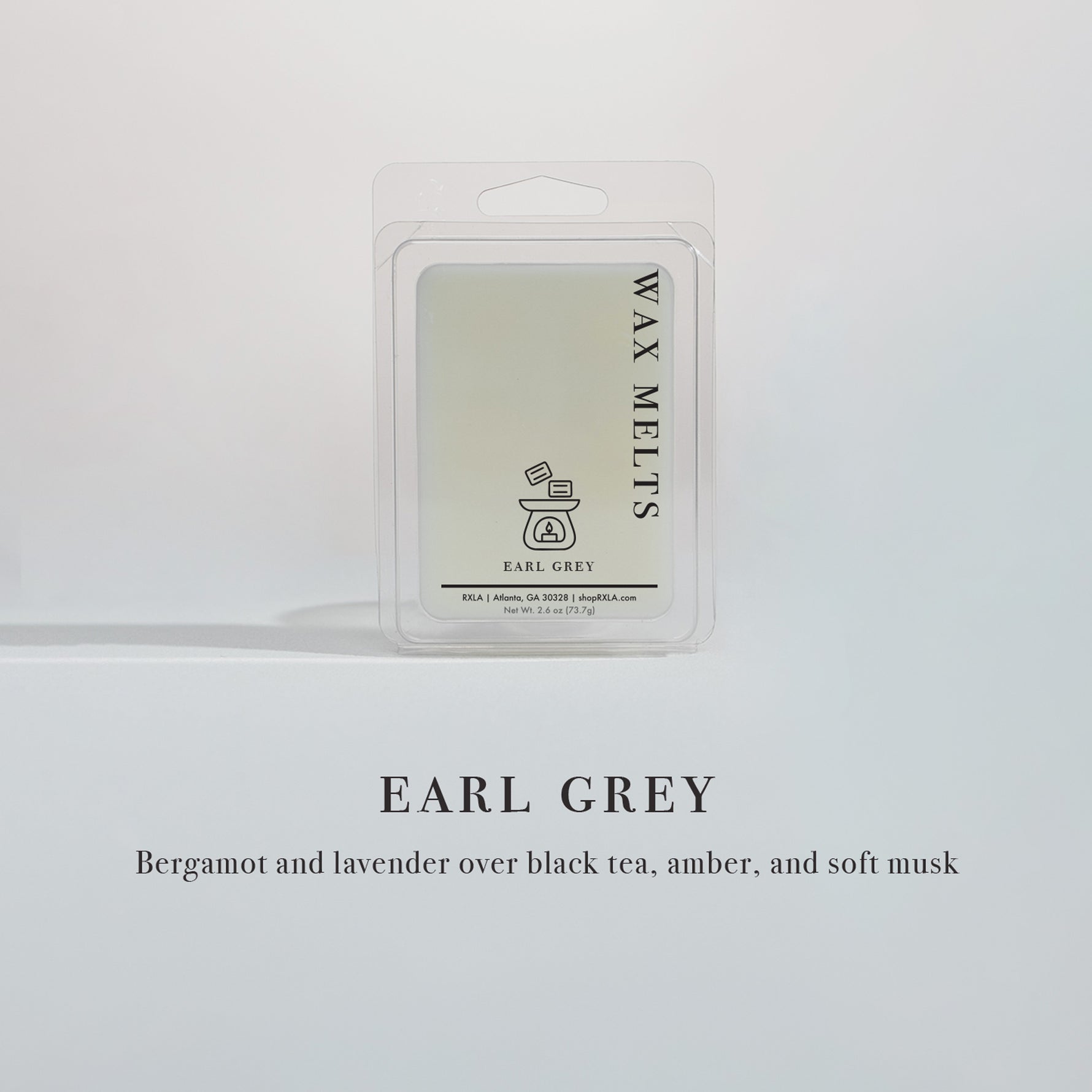 Lit Earl Grey candle in a minimalist jar—flame flickers as notes of bergamot, lavender, black tea, amber, and musk fill the space with warmth and calm.