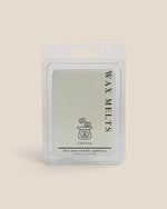 A packaged wax melt product in a clear plastic clamshell package with a white backing card, labeled 'WAX MELTS' and 'SANTAL' on a warm beige background.