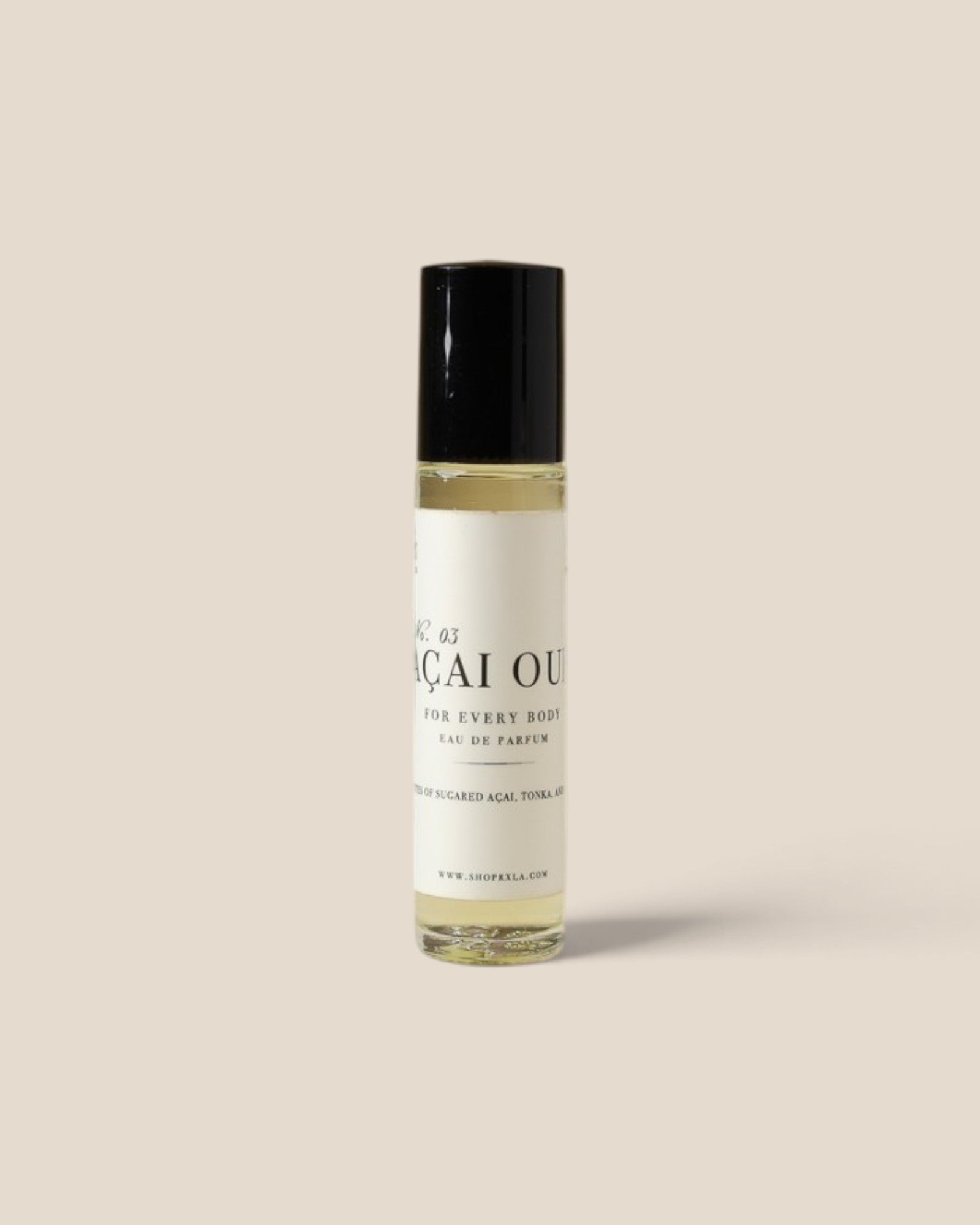 A small cylindrical rollerball bottle of Aqai Oud fragrance oil with a black cap and a white label, set against a solid beige background.