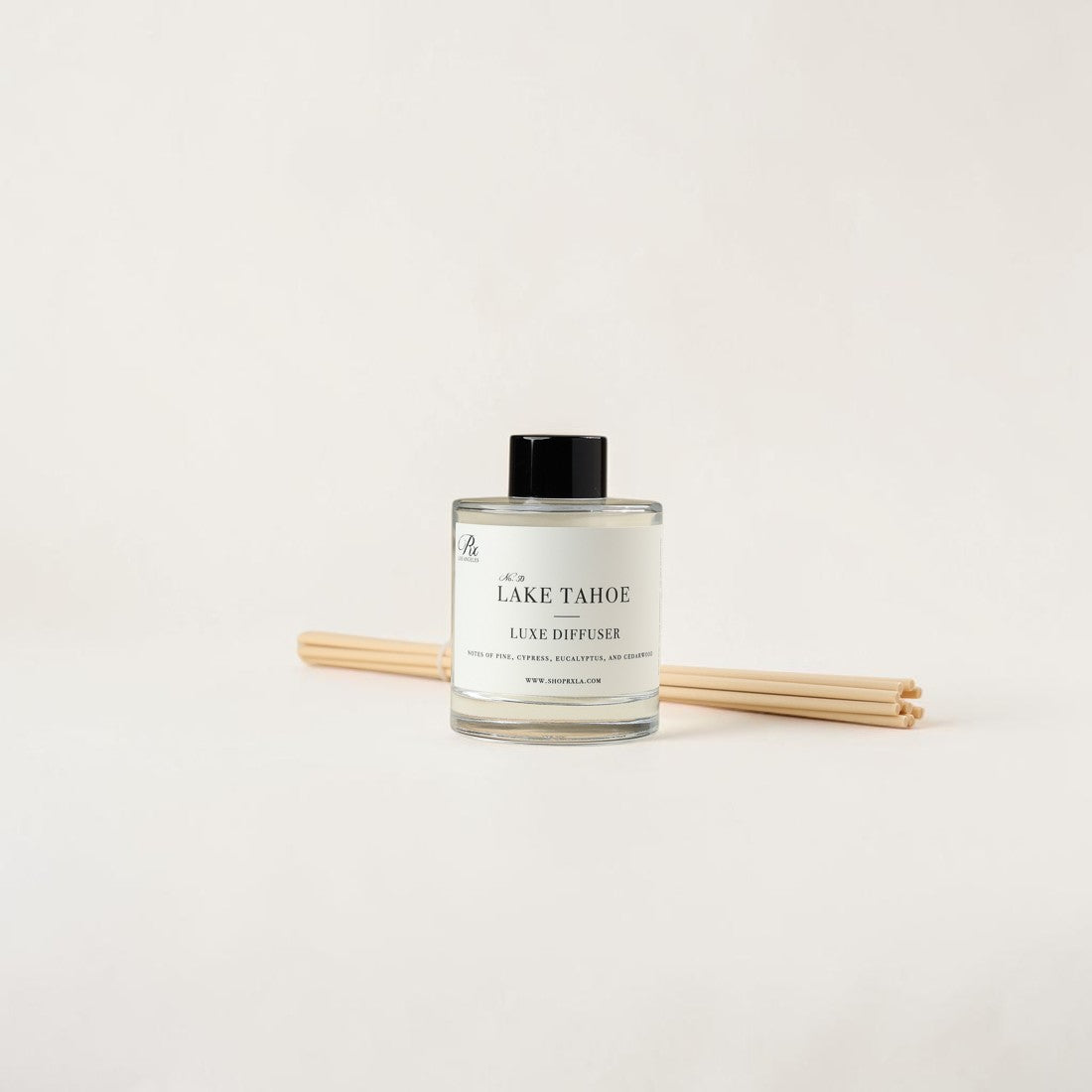 A reed diffuser bottle with a black cap and natural wood reeds, labeled 'LAKE TAHOE' and 'LUXE DIFFUSION', on a clean off-white background.