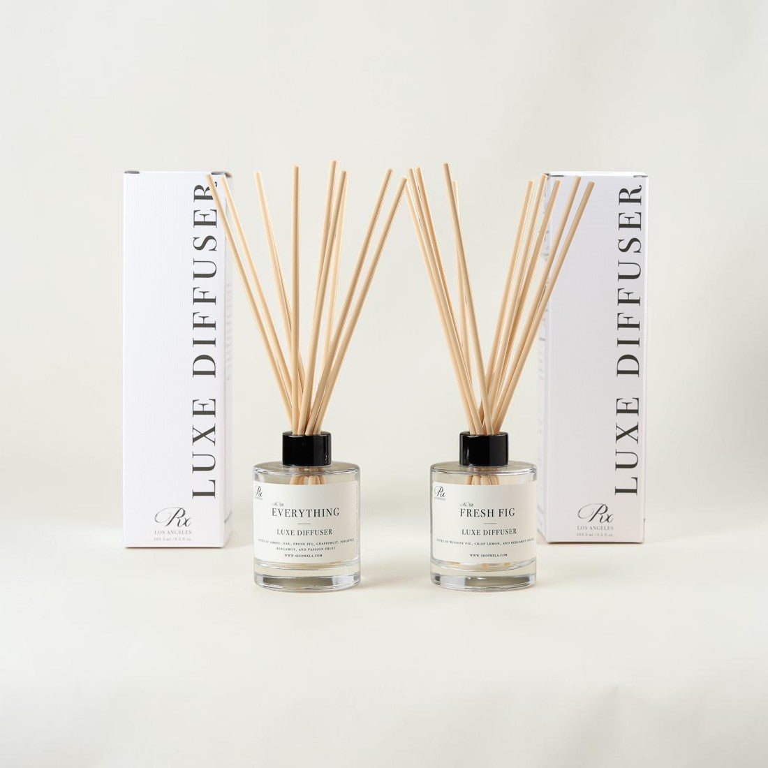 Two reed diffuser bottles with natural wooden reeds, displayed in front of their white packaging boxes on a clean white background. The front labels read 'EVERYTHING' and 'THE FRESH PIC', with vertical text on the boxes reading 'LUXE DIFFUSER'.