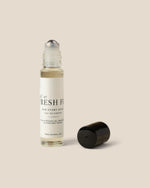 A clear glass rollerball bottle with a white label reading 'FRESH Fig