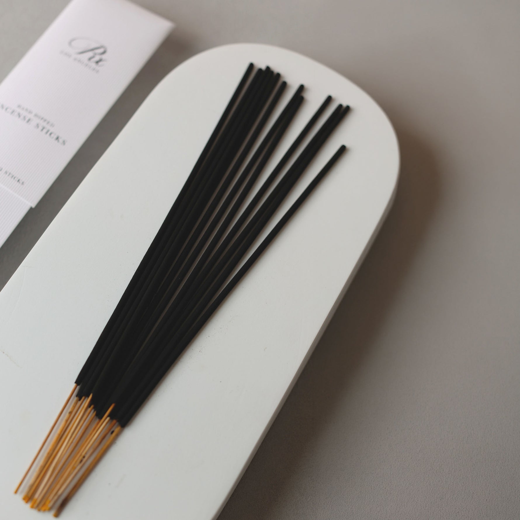 Incense sticks with a white holder on a neutral background